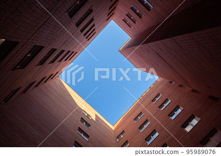 Brick high-rise new square house on a blue sky background. 95989076