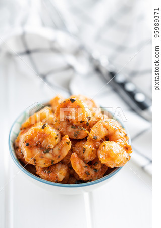 Grilled tiger shrimps in bowl on white table. 95989371