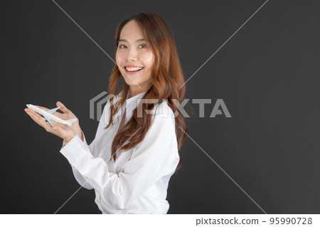 Business woman wearing white shirt Hand holding a white toy plane. Business woman wearing white shirt Hand holding a white toy plane. 95990728