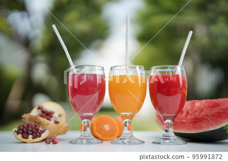 Orange juice, pomegranate juice and watermelon juice on the natural background 95991872