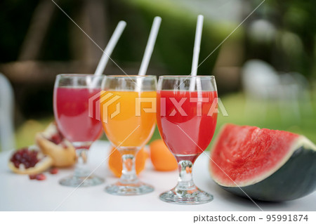 Orange juice, pomegranate juice and watermelon juice on the natural background 95991874