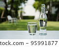 A glass of clean drinking water and a water bottle. 95991877