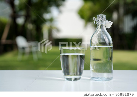 A glass of clean drinking water and a water bottle. 95991879