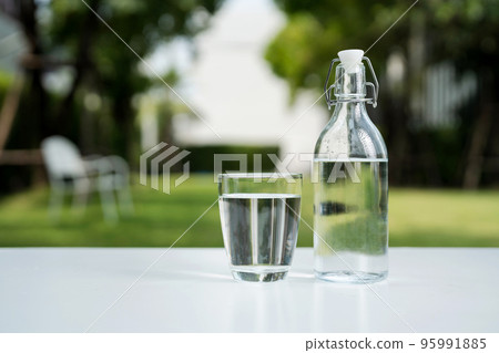 A glass of clean drinking water and a water bottle. 95991885