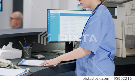 Medical assistant helping doctor with checkup report papers, working on healthcare appointments with insurance. Nurse and specialist talking about consultation and examination. Medical assistant helping doctor with checkup report papers, working on healthcare appointments with insurance. Nurse and specialist talking about consultation and examination. 95992216