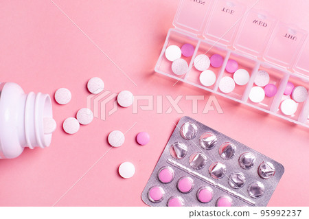 Beautiful closeup of tablet vitamin for women on pink background . Medical healthcare pillbox for a week. Medicine medical health. Beautiful closeup of tablet vitamin for women on pink background . Medical healthcare pillbox for a week. Medicine medical health. 95992237