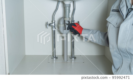 Piping repair image under the washbasin | Worker with a spanner 95992471