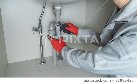 Piping repair image under the washbasin | Worker with a spanner 95992483