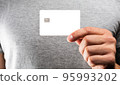 Man's hand holding credit card. 95993202