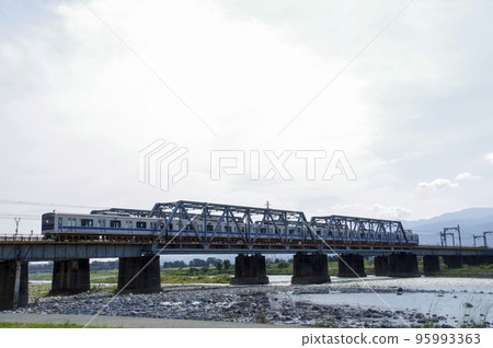 A train crossing the iron bridge over the Sakawa River 95993363