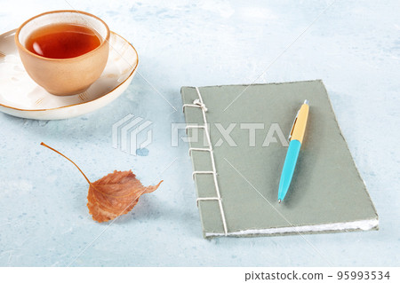 A diary. A paper journal with a pen, an autumn leaf, and a cup of tea 95993534