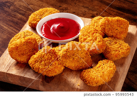 Chicken nuggets with ketchup on a rustic wooden background 95993543