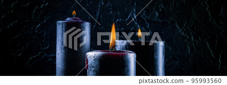 Burning candles on a dark background Burning candles on a dark background 95993560