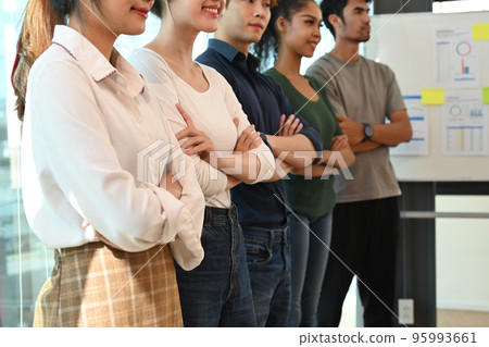 Successful business team standing with crossed arms in start up office. Cropped shot Successful business team standing with crossed arms in start up office. Cropped shot 95993661