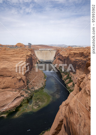 Aerial View Of Glen Canyon Dam And Colorado River Amidst Majestic Canyons Against Cloudy Sky In Arizona During Summer 95993902