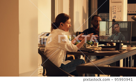 Entrepreneur attending business videoconference meeting on webcam with employee, talking on online videocall connection. Using teleconference call on computer at sunset, remote conversation. 95993941