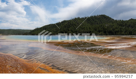 Beautiful view of famous Grand Prismatic Spring with sky in background. Panoramic geothermal landscape in Midway Geyser Basin. Tourist sightseeing attraction at famous Yellowstone national park. 95994257