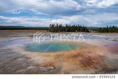 Scenic view of beautiful Grand Prismatic Spring with cloudy sky in background. Geothermal landscape in Midway Geyser Basin during summer. Famous tourist attraction at Yellowstone national park. 95994329