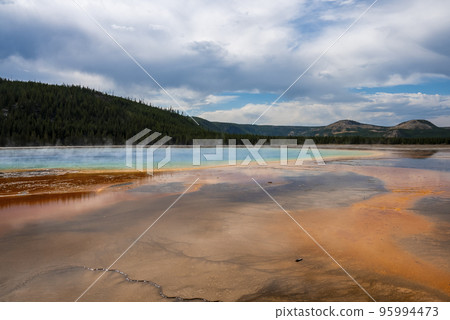 Scenic view of smoke emitting from Grand Prismatic Spring. Geothermal landscape at famous Yellowstone national park with sky in background. Tourist sightseeing attraction in Midway Geyser Basin. Scenic view of smoke emitting from Grand Prismatic Spring. Geothermal landscape at famous Yellowstone national park with sky in background. Tourist sightseeing attraction in Midway Geyser Basin. 95994473