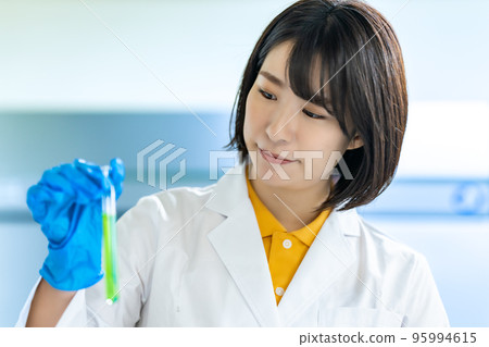 A woman in a white coat doing research 95994615