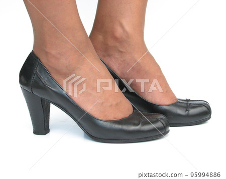 Female feet in black secretary shoes on white background Female feet in black secretary shoes on white background 95994886