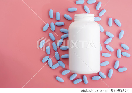 White plastic bottle with blue pills, vitamins or food supplemets. Blank container with medication pills on pink background. White plastic bottle with blue pills, vitamins or food supplemets. Blank container with medication pills on pink background. 95995274