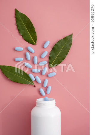 Natural food supplements pills, white plastic bottle with vitamins, pink background and sun light with shadows. Natural food supplements pills, white plastic bottle with vitamins, pink background and sun light with shadows. 95995276
