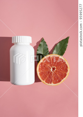 Natural food supplements pills, white plastic bottle with vitamins, pink background and sun light with shadows. Natural food supplements pills, white plastic bottle with vitamins, pink background and sun light with shadows. 95995277