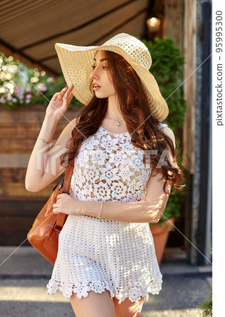 Fashion woman portrait of young pretty trendy girl posing at the city in Europe, summer street fashion, straw hat, laughing and smiling portrait. 95995300