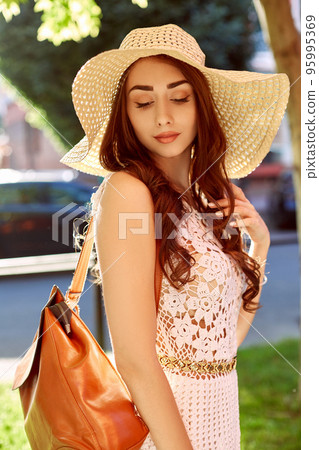 Sunny lifestyle fashion portrait of young stylish hipster woman walking on the street, wearing trendy outfit, straw hat, travel with backpack. Sunny lifestyle fashion portrait of young stylish hipster woman walking on the street, wearing trendy outfit, straw hat, travel with backpack. 95995369