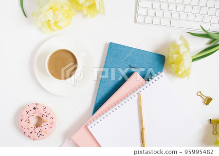 Notebook for daily planning with breakfast serving on a white background, a cup of coffee, a donut, flowers and a gift box with a bow. The concept of daily planning of life, work, study. Mother's Day 95995482