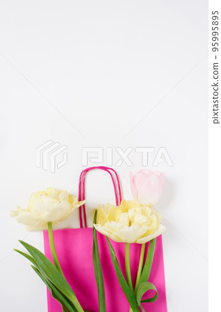 Bouquet of pink and yellow tulips on a pink wrapper on a white background. Valentines day, mothers day, women's day, spring, easter concept. Flat lay, top view, copy space Bouquet of pink and yellow tulips on a pink wrapper on a white background. Valentines day, mothers day, women's day, spring, easter concept. Flat lay, top view, copy space 95995895