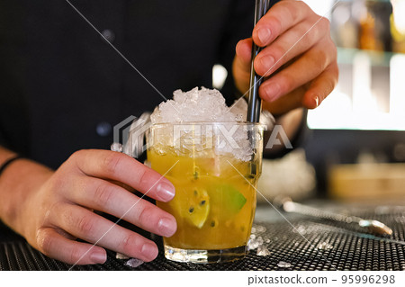 Barman is making cocktail at night club in a classic cocktail glasses. 95996298