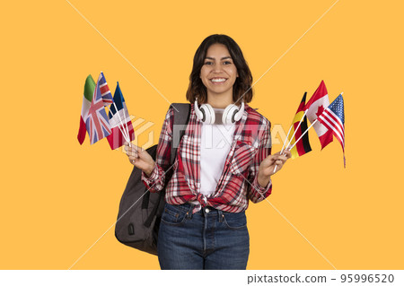 Happy middle eastern woman student holding diverse flags Happy middle eastern woman student holding diverse flags 95996520