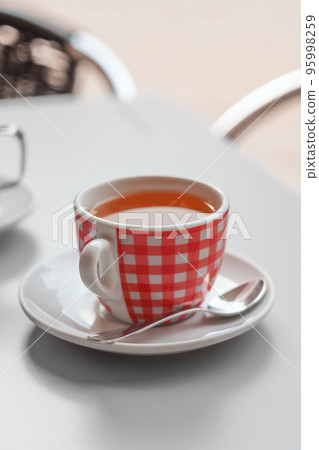 Black tea cup in a european city cafe close up. Urban style Black tea cup in a european city cafe close up. Urban style 95998259
