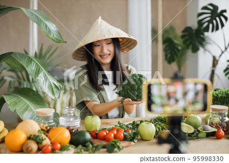 Beautiful female using broccoli, vegetables and fruits preparing healthy salad 95998330