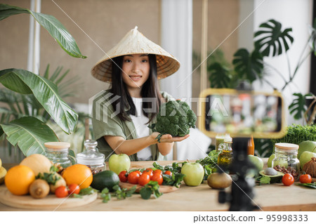 Beautiful female using broccoli, vegetables and fruits preparing healthy salad Beautiful female using broccoli, vegetables and fruits preparing healthy salad 95998333