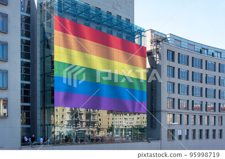 Giant LGBT flag on the huge screen on the building wall. Pride Flag, rainbow flag of the LGBT community. Minorities, protection and equality concept, pride month in a city. 95998719