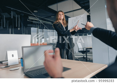 Attractive business woman during meeting showing her project to colleagues 95999283