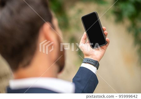 Man holding a smartphone in hand Man holding a smartphone in hand 95999642