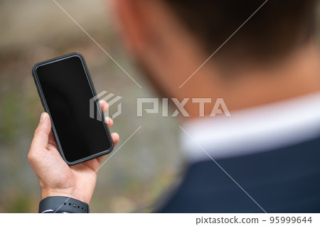 Man holding a smartphone in hand 95999644