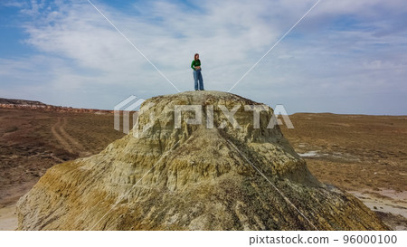 Caucasian woman stands on a clay hill. 96000100