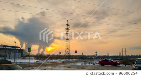 Industrial landscape. Red car and power lines against the backdrop of sunset and smoke from the chimneys of a thermal power plant Industrial landscape. Red car and power lines against the backdrop of sunset and smoke from the chimneys of a thermal power plant 96000254