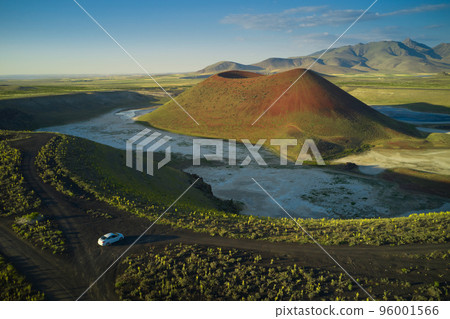 Aerial landscape of Meke Crater in Turkey. View of green valley with the crater lake and the car. Travel destination. Aerial landscape of Meke Crater in Turkey. View of green valley with the crater lake and the car. Travel destination. 96001566