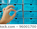 Invisible dental aligner at blue boxes backdrop. Orthodontic plastic transparent braces for teeth straightening  96001700