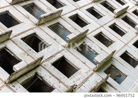 A damaged abandoned panel house with decorative facade of small white tiles. A damaged abandoned panel house with decorative facade of small white tiles. 96001752