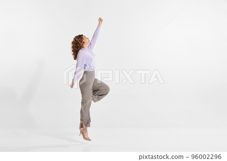 Portrait of young woman reaching top isolated over white studio background. Growing professional ambitions Portrait of young woman reaching top isolated over white studio background. Growing professional ambitions 96002296