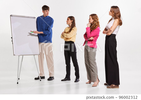 Portrait of young man, coach, mentor, teacher having offline lesson with trainees. Taining courses Portrait of young man, coach, mentor, teacher having offline lesson with trainees. Taining courses 96002312