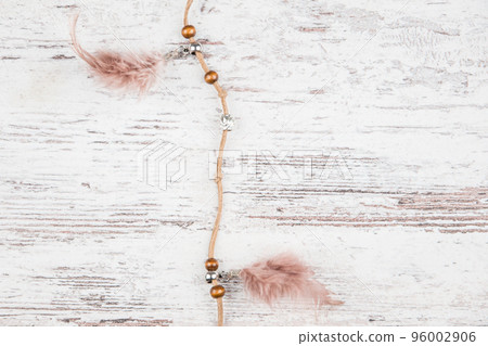 Handmade dream catcher with feathers threads and beads rope hanging on a light background boards Handmade dream catcher with feathers threads and beads rope hanging on a light background boards 96002906
