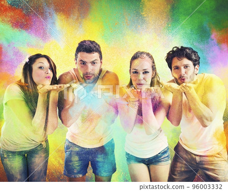 Friends blowing colored powders 96003332